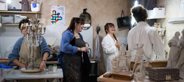 Atelier pratique où des jeunes manipulent un luminaire et une sculpture
