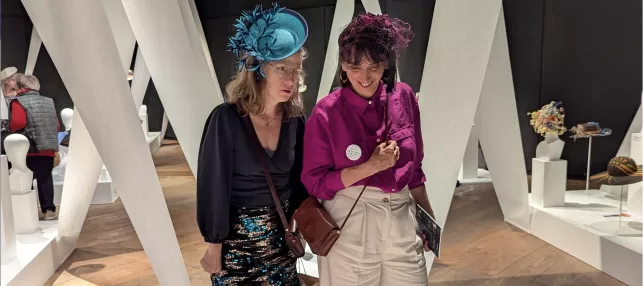 Deux femmes portant des chapeaux à une exposition