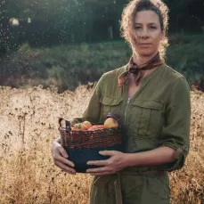 artisan d'art vannier dans un champ et son panier en osier