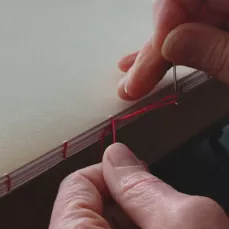 Stagiaire en train de réaliser une reliure cousue, formation pro