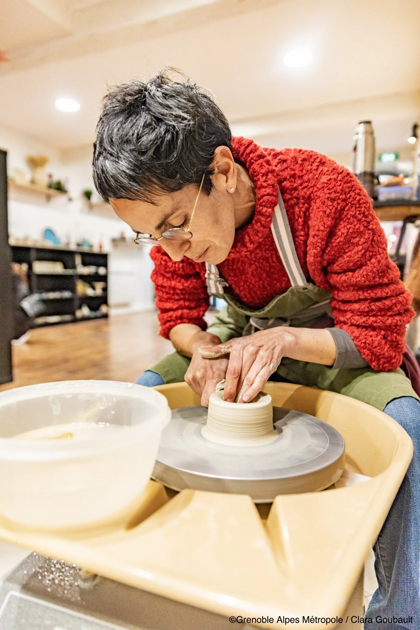 Céramiste au tour de potier, façonnant une pièce en grès dans l’Atelier Kaolin à Grenoble