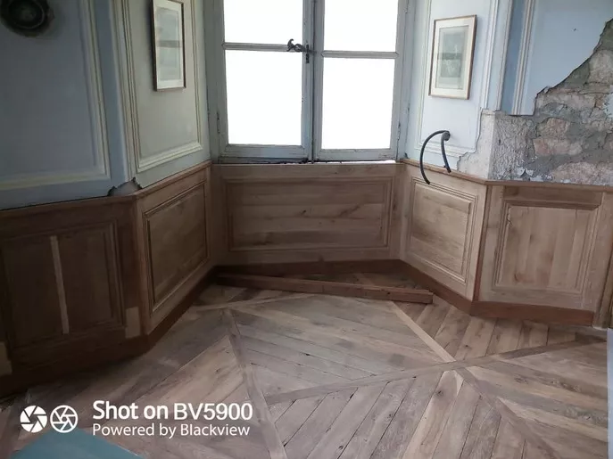 Restauration des lambris bas du grand salon de château.