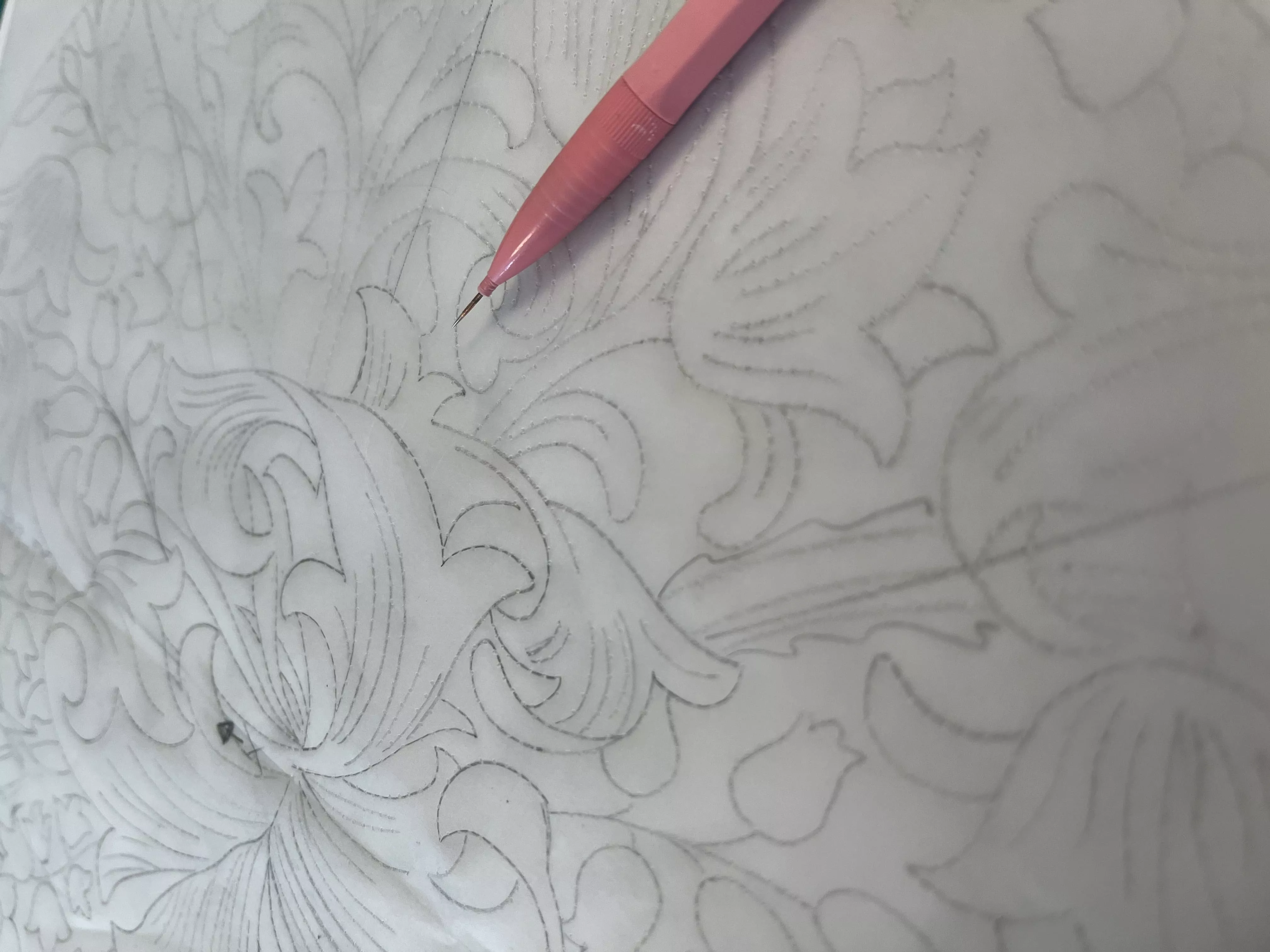 Photo d'un poncif. Le poncif est une feuille de calque, sur laquelle on a décalqué son motif. On perce ensuite le motif avec une aiguille logée dans un porte-mine. Puis, on utilisera une petite chaussette remplie de poudre de fusain qui passera dans les petits trous, et le motif sera ainsi transféré.