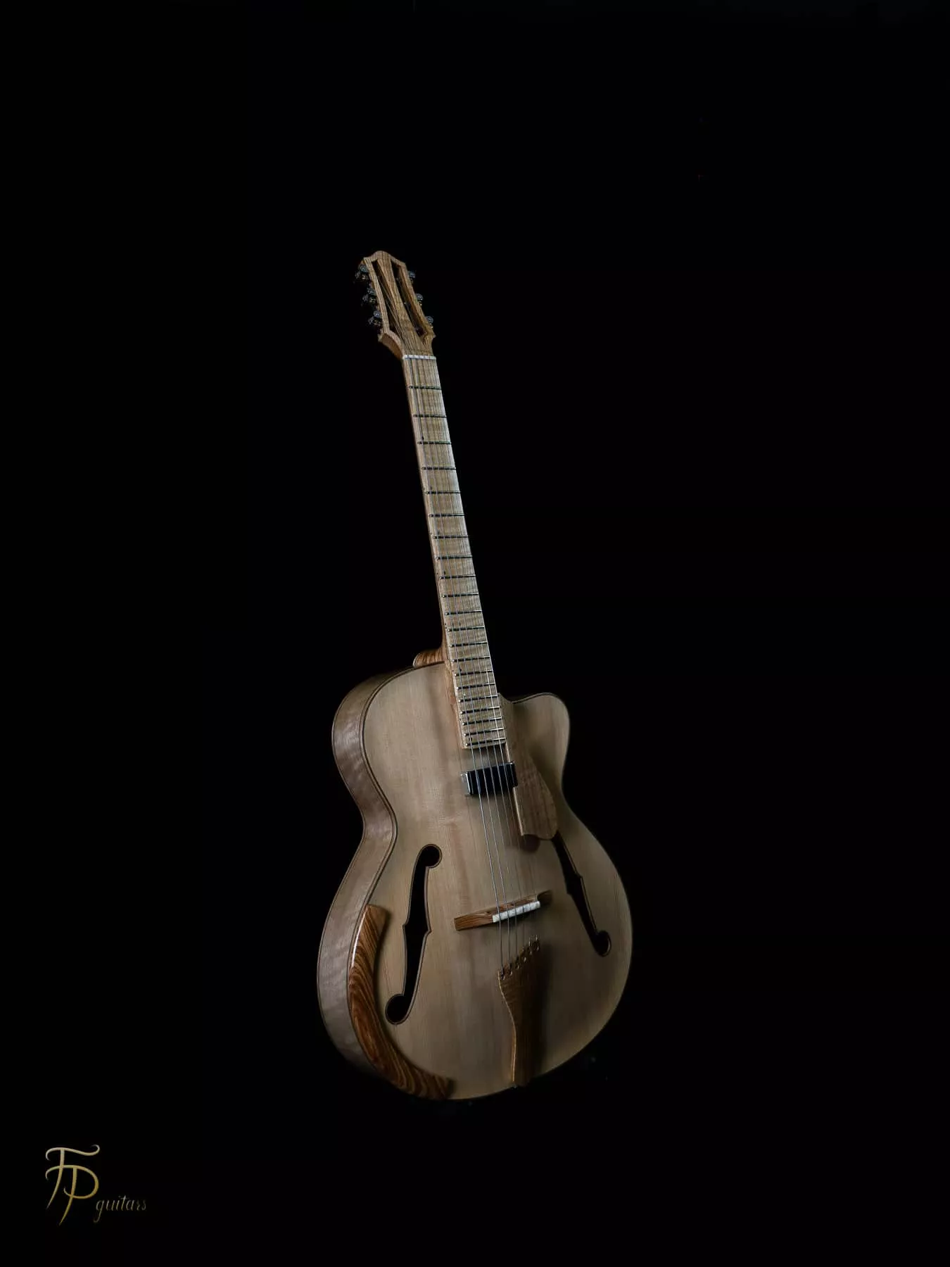Archtop traditionnelle réalisée entièrement à partir de bois locaux : table sculptée en épicéa alpin, éclisses en noyer et autres éléments principaux en frêne. L’instrument est intégralement fini au vernis au tampon, appliqué en couches fines afin de préserver et révéler le caractère naturel des essences. Son amplification sur mesure associe un micro magnétique dissimulé sous la touche à quatre capteurs piézoélectriques, avec des volumes indépendants.