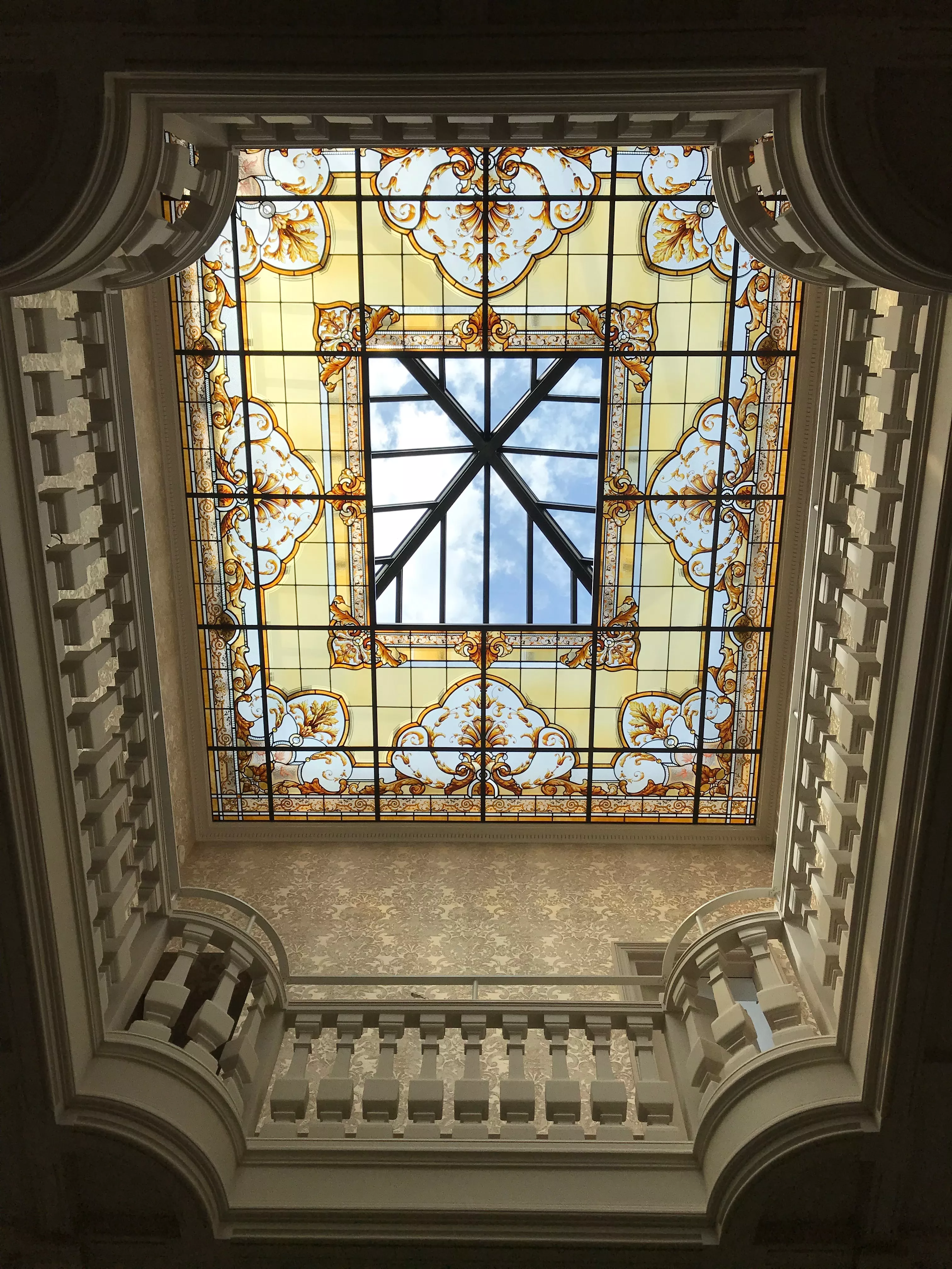 Création de vitrail de plafond et coupole à Paris par France Vitrail International, verrière d'art classique à motifs d'arabesques dorées.