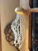 Méduse composée d'un test d'oursin doré à la feuille d'or avec tentacules en tulle transparent orné de plumetis blanc brodé de fils dorés et filaments dorés; cordon de suspension blanc et doré