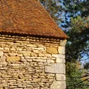 Architecture rurale en pierre calcaire blonde pourvue d'une toiture en bardeaux de bois de châtaignier.