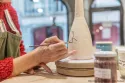 Carine Billard, céramiste de l’Atelier Kaolin à Grenoble, décorant une pièce en grès dans son atelier.