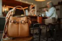 Une mère et sa fille grignotant sur une table de cuisine avec le sac Sellier Essentiel en premier plan