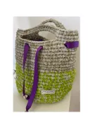 Ce sac à main est entièrement réalisé à la main à partir de bandes de tulle et de soie recyclées, travaillées au crochet pour créer une texture riche et volumineuse. Son design bicolore associe des nuances de vert anis et de beige naturel, rehaussées par d'élégants rubans violets qui apportent une touche contemporaine et raffinée
