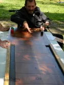 Une personne âgée en fauteuil joue au jeu de galet, un jeu fabriqué en bois de récupération par T'envoies du Bois ! Photo prise lors d'une animation de jeux en bois à Toulouse.