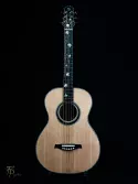 Guitare acoustique au format 00, entièrement réalisée à la main. Sa table en épicéa de Sitka est soulignée par des filets d’ébène et de nacre qui accompagnent le contour de la caisse et la rosace. Un décor floral en nacre et en laiton se déploie de la tête jusqu’à la touche, mêlant précision technique, finesse du trait et jeux de lumière. Cette ornementation a été pensée comme une composition continue, intégrée à l’architecture de l’instrument.