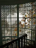 Restauration et rénovation de vitrail d'escalier d'immeuble haussmannien à Paris par France Vitrail International, cage d'escalier en marbre et ferronnerie d'art.