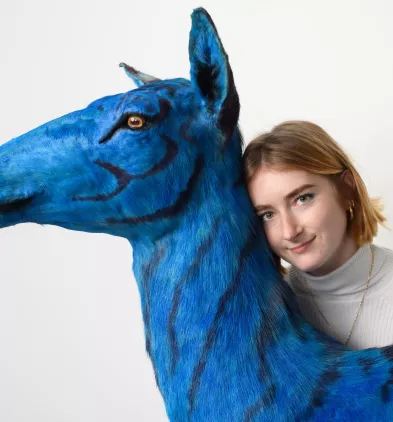 Claire Caron Mayor, apprentie taxidermiste posant avec son œuvre Biche azurée