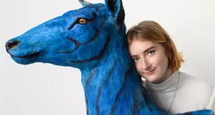 Claire Caron Mayor, apprentie taxidermiste posant avec son œuvre Biche azurée