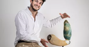 Lauréat du 3e prix niveau 3, étudiant en CAP décor sur verre, posant avec son œuvre, une sculpture en verre sur pied