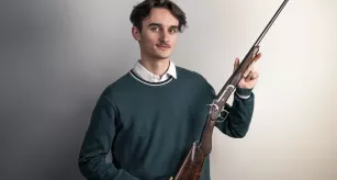 Mathis Fortier-Durand, étudiant en armurie, posant avec son œuvre, une carabine Pauly